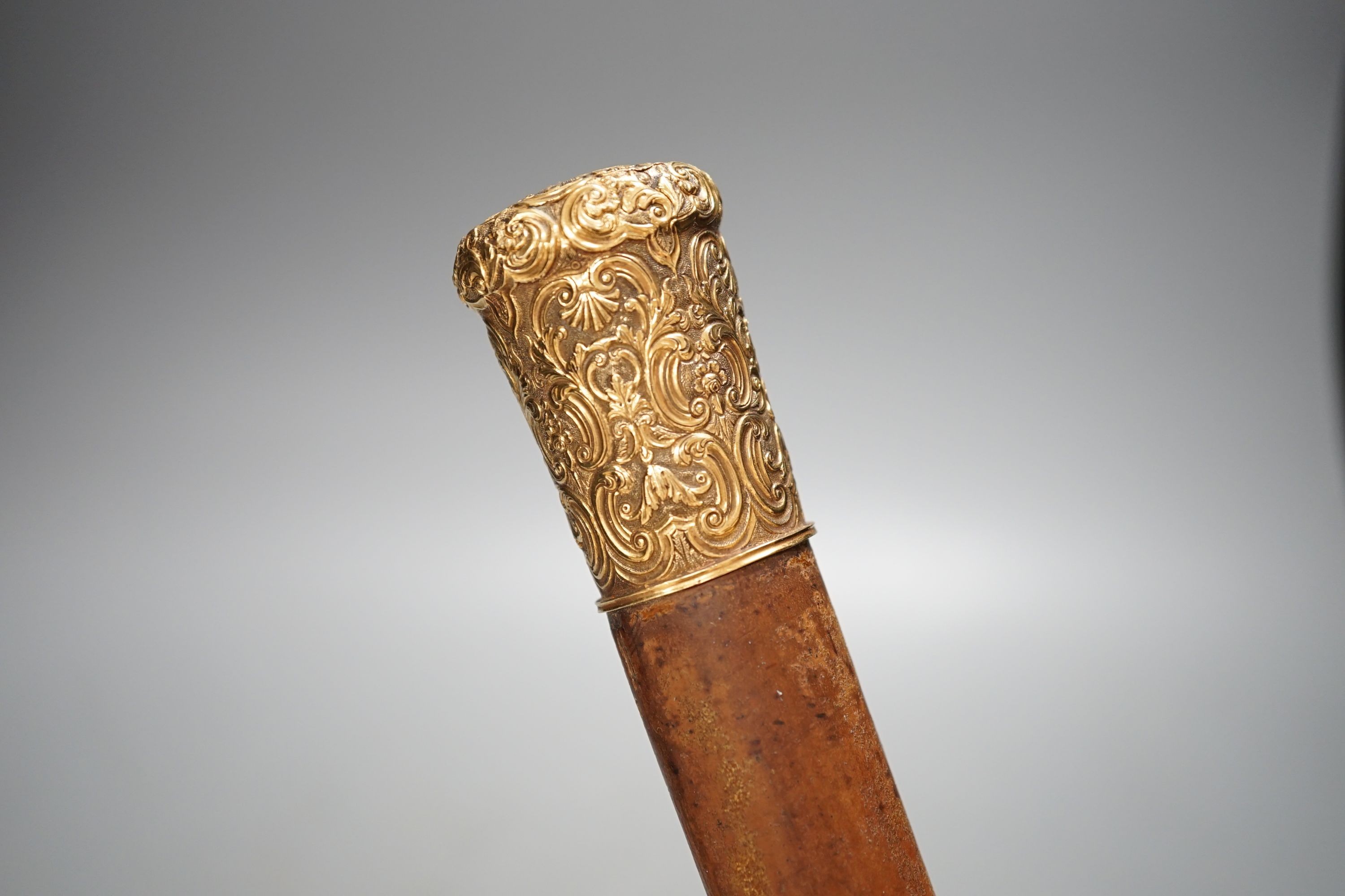 A 19th century malacca walking cane, with embossed yellow metal mount, 95cm.